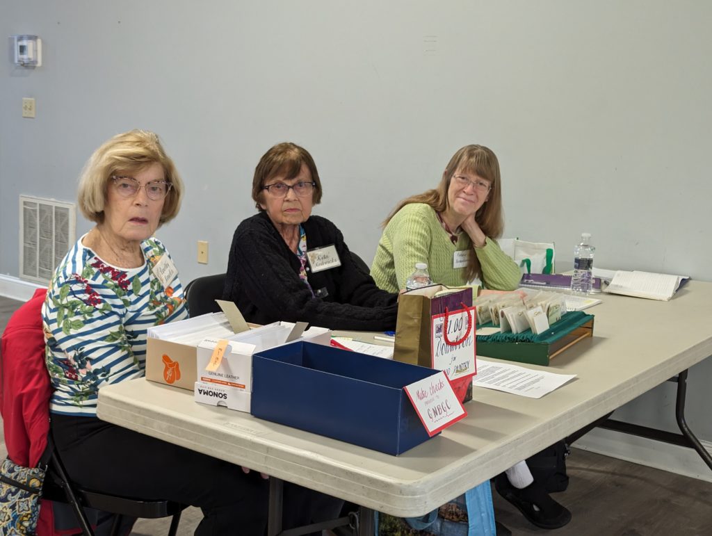 Three Garden Club members at a table accepting membership applications